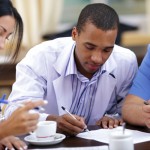 Young african-american doctor making notes at the medical meeting